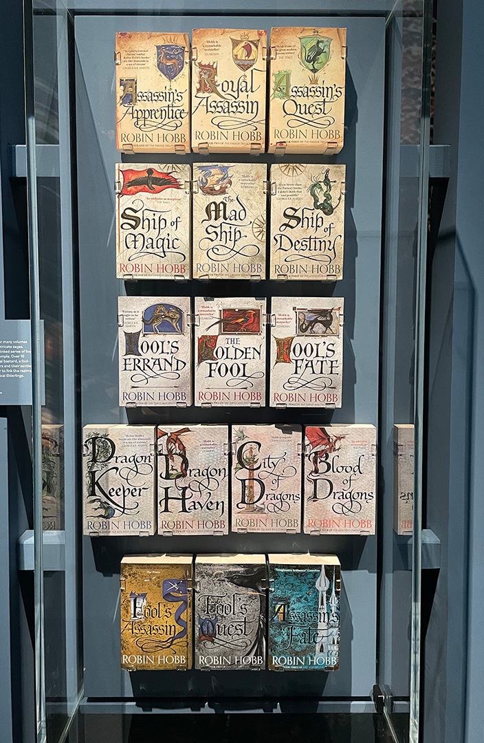 Photograph of display case at the British Library featuring all 16 books